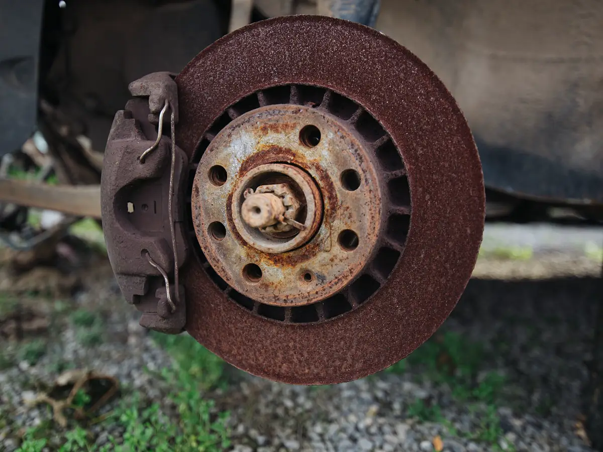 Rusty brake disc and caliper on a car with the wheel removed