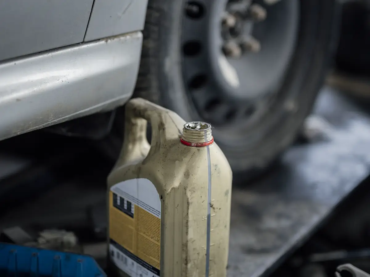 Oil being poured into an engine through a funnel during a routine oil change